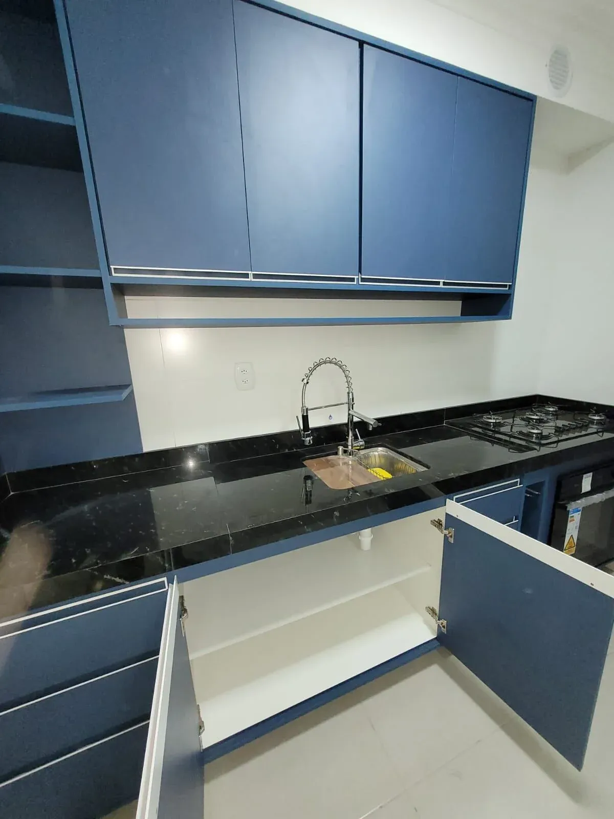 Armários de cozinha abertos mostrando prateleiras internas