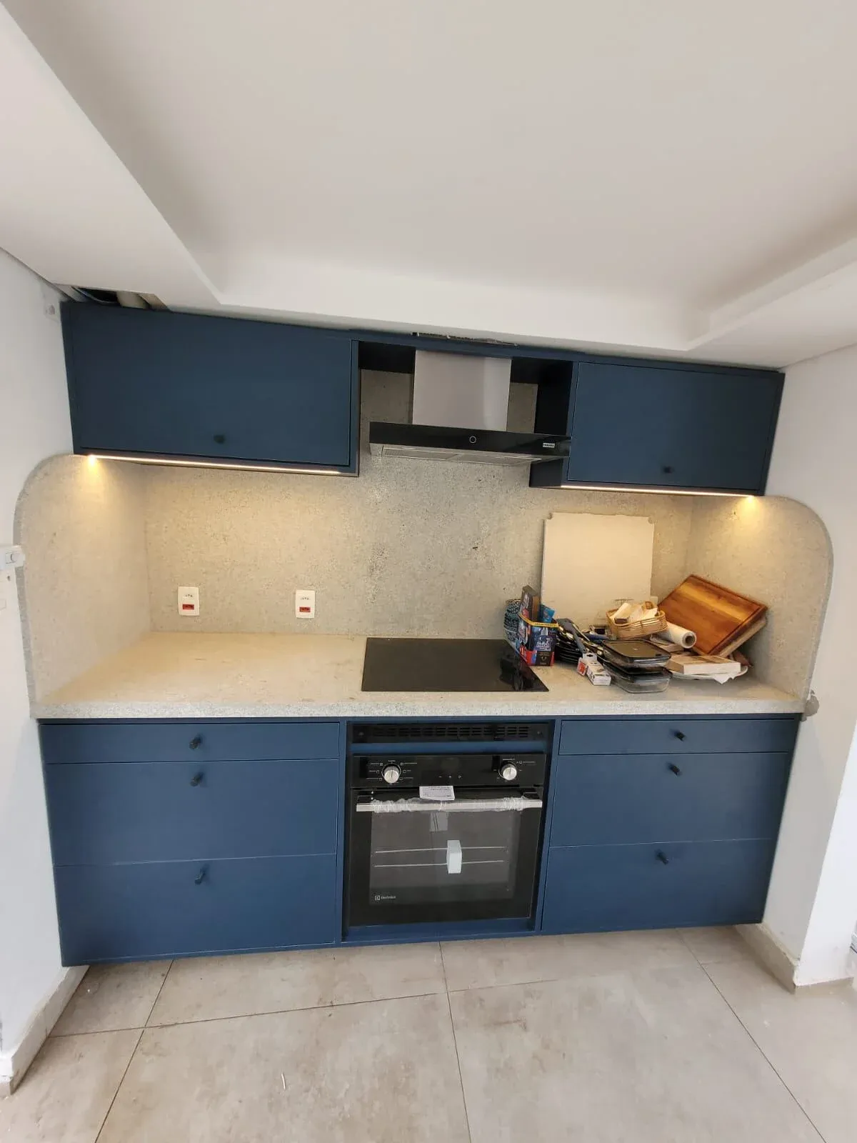 Cozinha planejada azul com forno embutido e bancada em granilite